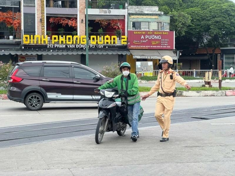 Băng ngang đường ray xe lửa, nhiều tài xế bị CSGT TP.HCM xử lý- Ảnh 1.