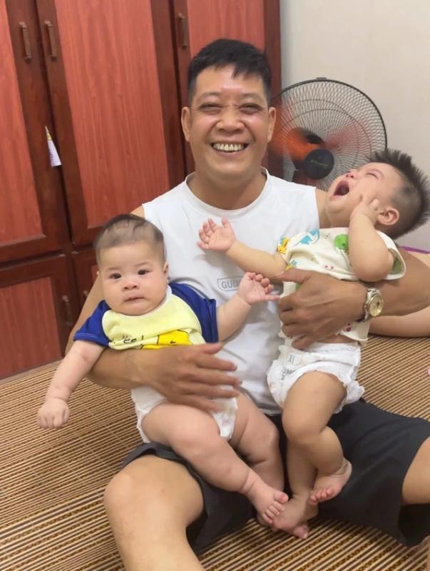 Một tay bế con, một tay bế cháu: Người đàn ông 50 tuổi khiến mạng 'dậy sóng' - Ảnh 1. Một tay bế con, một tay bế cháu: Người đàn ông 50 tuổi khiến mạng 'dậy sóng' - Ảnh 1.