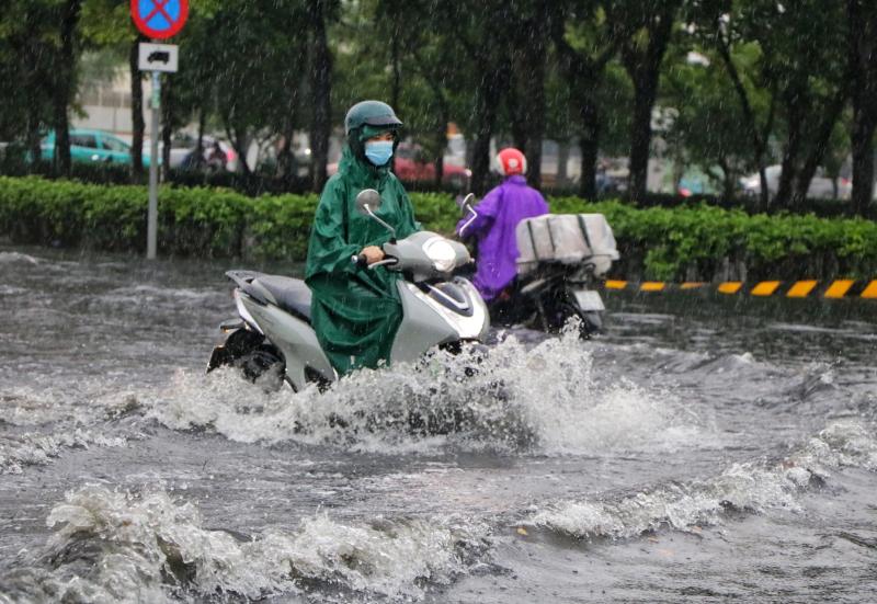 TP.HCM có mưa rất to chiều nay: Nước ngập gần hết bánh xe, người dân 'vượt sóng'- Ảnh 1. TP.HCM có mưa rất to chiều nay: Nước ngập gần hết bánh xe, người dân 'vượt sóng'- Ảnh 1.
