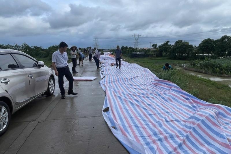 Hà Nội cấm phương tiện qua đê hữu Cầu vì mặt đê sụt lún 70 m - Ảnh 1.