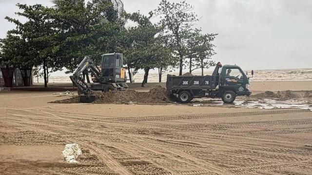 Nhiều người dân trộm cát biển trôi dạt trên đường giao thông - Ảnh 1.