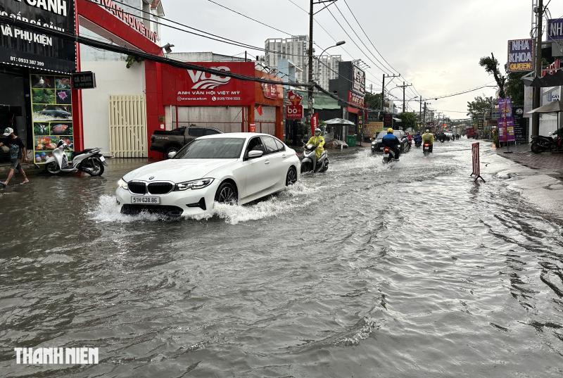 Mưa lớn giữa trưa ở TP.HCM, đường Nguyễn Duy Trinh ngập nước kéo dài- Ảnh 1.