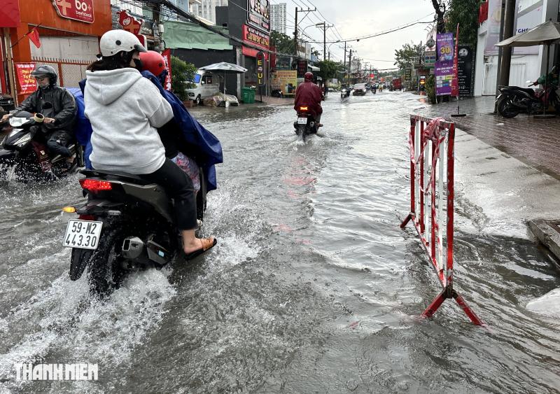 Mưa lớn giữa trưa ở TP.HCM, đường Nguyễn Duy Trinh ngập nước kéo dài- Ảnh 4.