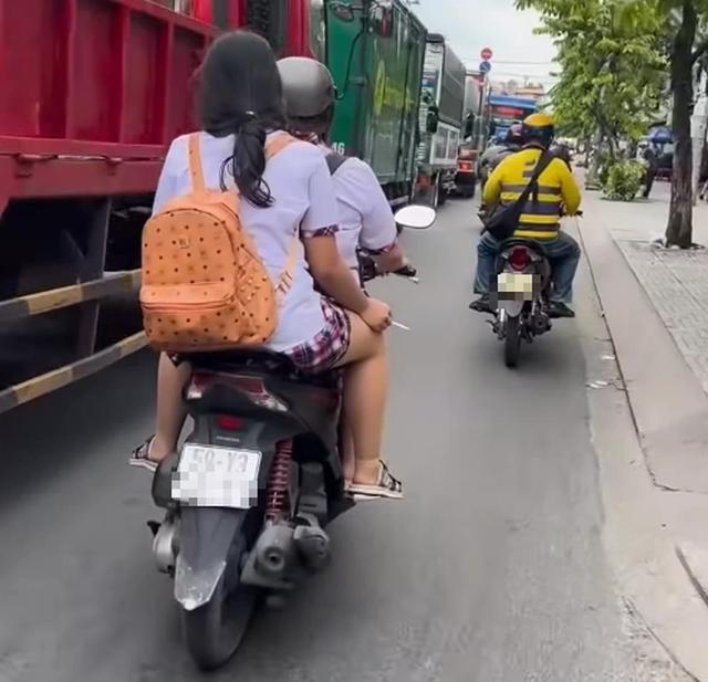 Hai nữ sinh chạy xe máy không đội mũ bảo hiểm, hút thuốc gây bức xúc- Ảnh 1.