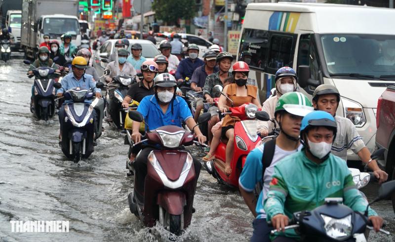 Đường ở TP.HCM ngập sâu do triều cường dâng cao, xe cộ chen chúc di chuyển - Ảnh 3.