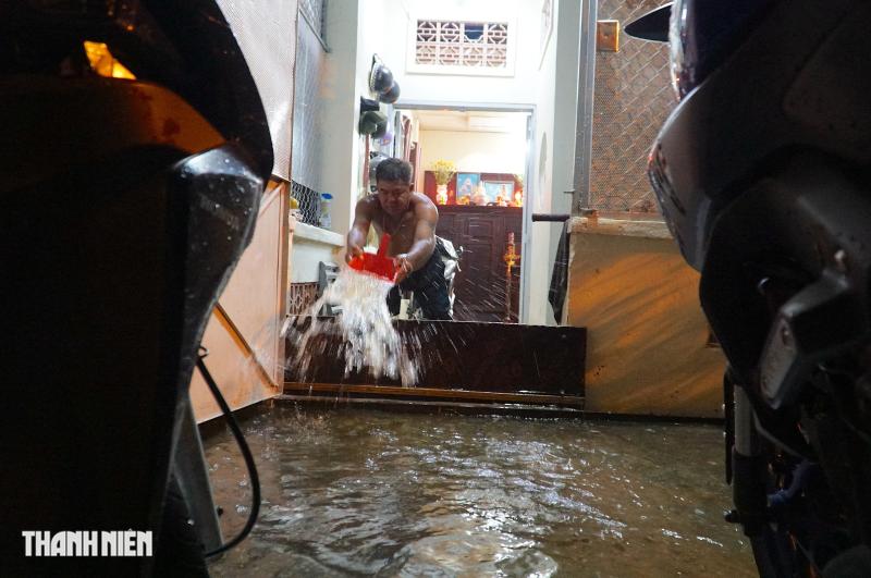 Triều cường dâng cao ở TP.HCM: Nhà ngập đến nửa đêm, người dân hì hục tát nước - Ảnh 1.