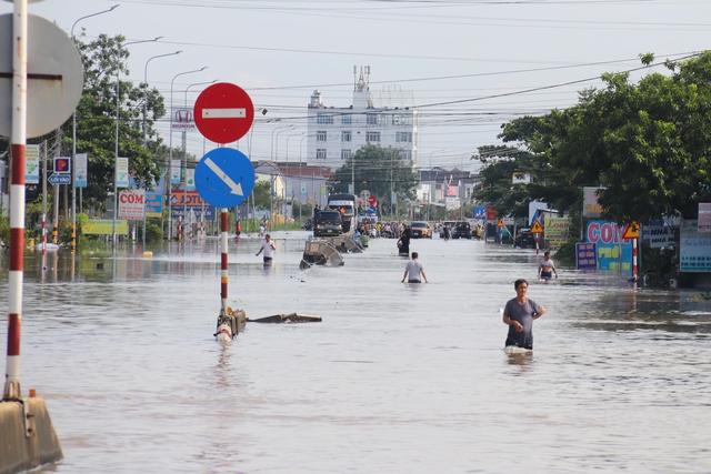 Nước lũ tràn về ngập lụt hàng trăm căn nhà tại Lâm Đồng gây tê liệt QL1 - Ảnh 1.