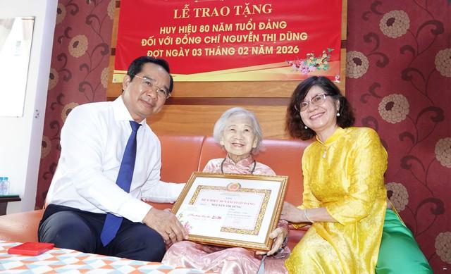  - Ảnh 1. Chủ tịch UBND TP.HCM Nguyễn Văn Được trao tặng Huy hiệu 80 năm tuổi Đảng cho cụ bà Nguyễn Thị Dũng (phường Thạnh Mỹ Tây)