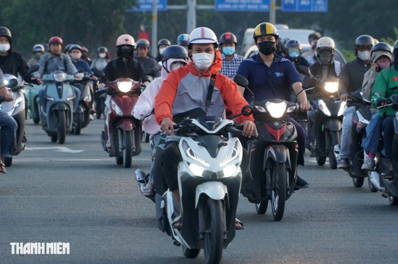 Sáng nay TP.HCM 17 độ, người dân mặc áo mưa chống lạnh khi đi đường - Ảnh 6.