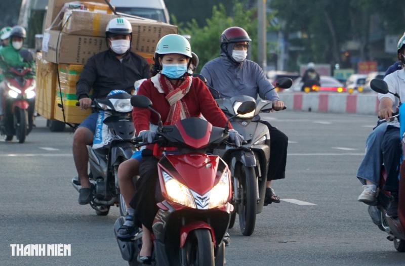 Sáng nay TP.HCM 17 độ, người dân mặc áo mưa chống lạnh khi đi đường - Ảnh 8.