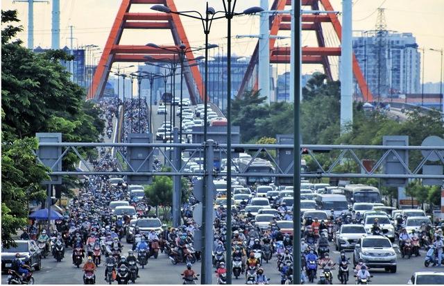 Vì sao TP.HCM chưa cho ô tô chạy vào làn xe máy trên đường Phạm Văn Đồng? - Ảnh 1.