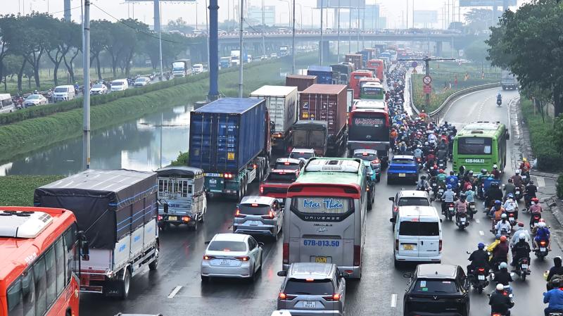 Cửa ngõ phía tây ùn ứ, CSGT dầm mưa điều tiết giao thông ngày cao điểm - Ảnh 1.