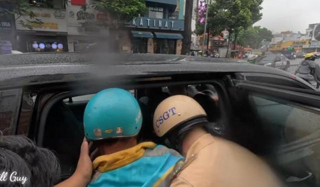 CSGT TP.HCM dầm mưa mở đường cứu tài xế công nghệ nghi đột quỵ - Ảnh 1.