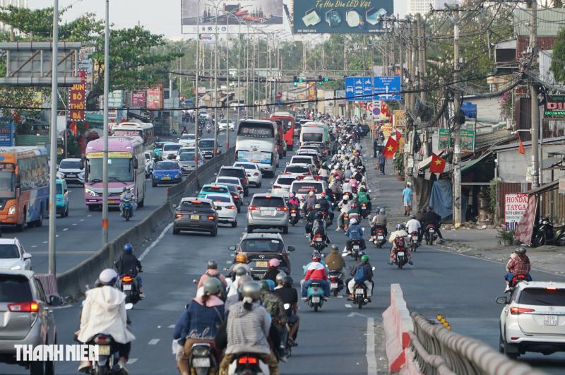 Chiều mùng 4 tết, quốc lộ 1 đông nghẹt người các tỉnh miền Tây trở lại TP.HCM - Ảnh 9.