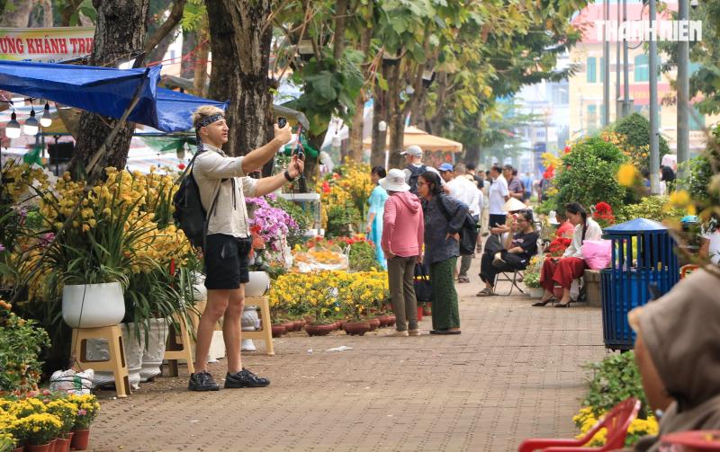 Khách Tây đi chợ hoa tết trung tâm TP.HCM, làm điều lạ khiến nhà vườn tò mò - Ảnh 2.