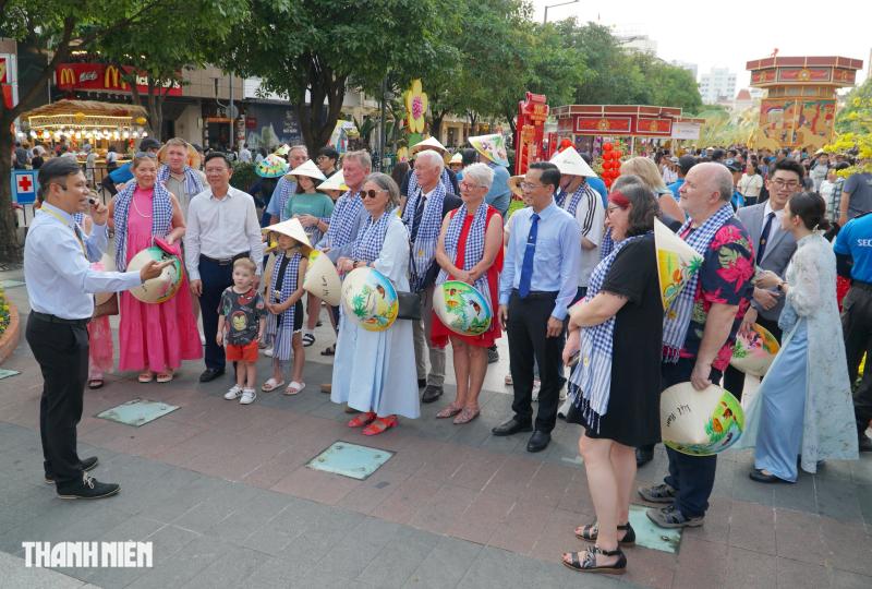 Khách quốc tế đến TP.HCM bất ngờ được lì xì, ăn bánh chưng chiều mùng 5 tết - Ảnh 6.