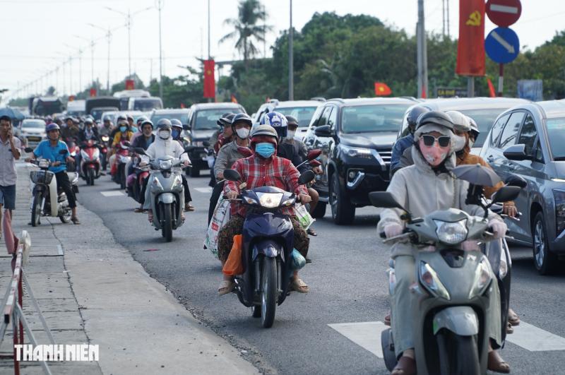 Chiều mùng 4 tết, quốc lộ 1 đông nghẹt người các tỉnh miền Tây trở lại TP.HCM - Ảnh 1.