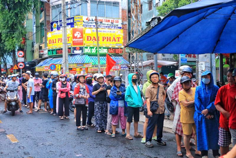 Sáng nay hàng dài người dân TP.HCM đội mưa mua vịt quay, heo quay ngày Thần tài   - Ảnh 1.