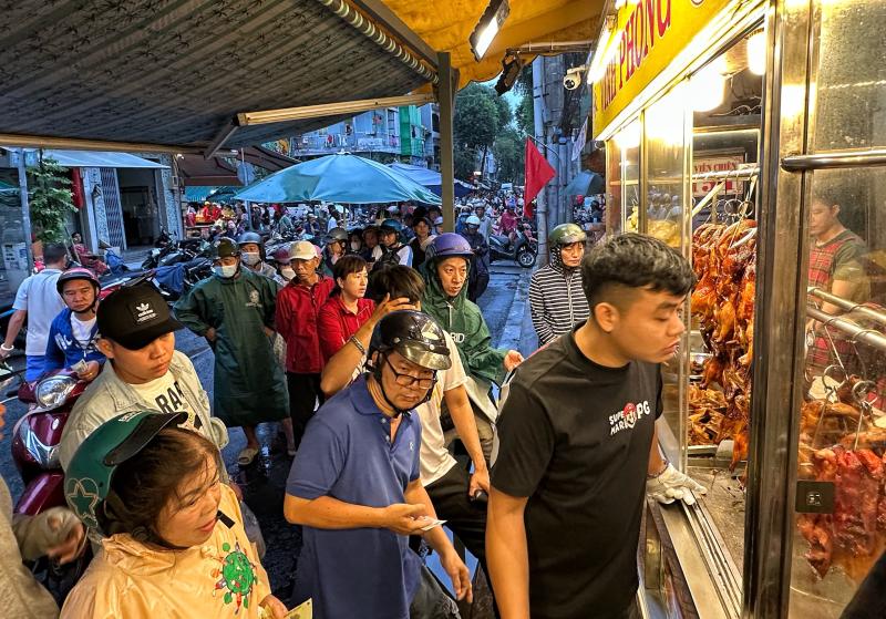 Sáng nay hàng dài người dân TP.HCM đội mưa mua vịt quay, heo quay ngày Thần tài   - Ảnh 3.