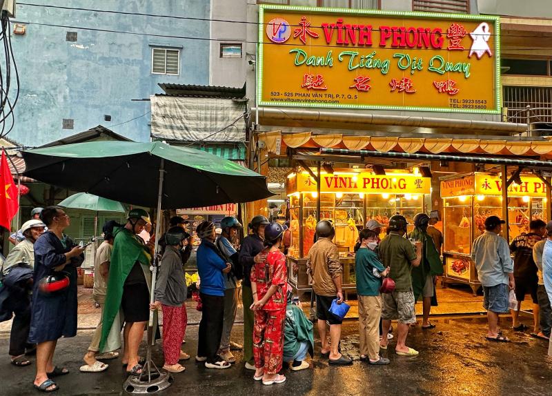 Sáng nay hàng dài người dân TP.HCM đội mưa mua vịt quay, heo quay ngày Thần tài   - Ảnh 2.