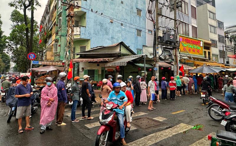Sáng nay hàng dài người dân TP.HCM đội mưa mua vịt quay, heo quay ngày Thần tài   - Ảnh 7.
