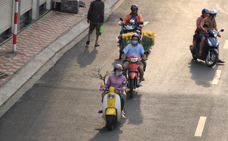 Đường phố TP.HCM ngày làm việc cuối cùng trước nghỉ tết: Người người 'chở tết về nhà'  - Ảnh 1.