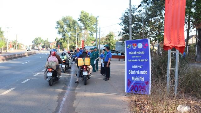Tiếp sức hàng ngàn chai nước, bánh cho người dân trên đường về quê đón tết- Ảnh 1.