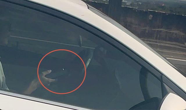 CSGT hóa trang trên cao tốc, tài xế vừa dùng điện thoại liền bị camera ghi lại - Ảnh 1.