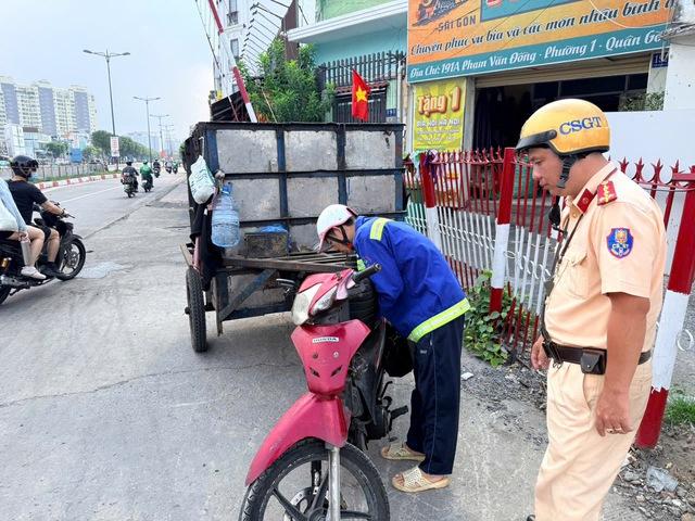 Xe rác tự chế thành 'chướng ngại vật di động' trên đường phố TP.HCM - Ảnh 1.