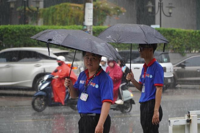 Bất chấp mưa đổ xối xả, tình nguyện viên che mưa tiếp sức thí sinh - Ảnh 17.