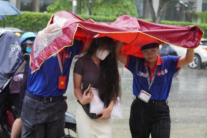 Bất chấp mưa đổ xối xả, tình nguyện viên che mưa tiếp sức thí sinh - Ảnh 14.