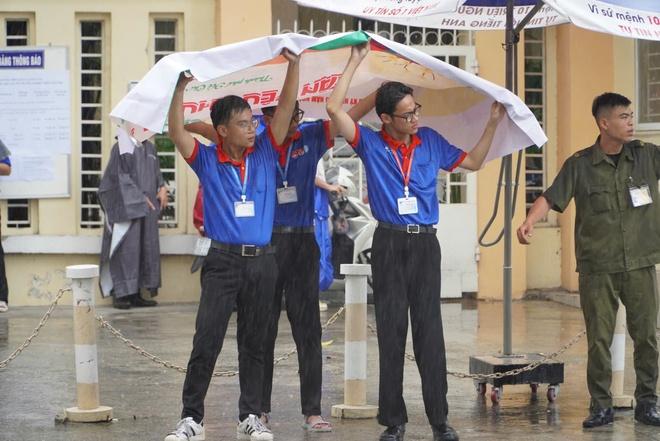 Bất chấp mưa đổ xối xả, tình nguyện viên che mưa tiếp sức thí sinh - Ảnh 16.