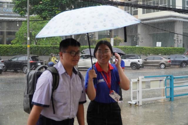 Bất chấp mưa đổ xối xả, tình nguyện viên che mưa tiếp sức thí sinh - Ảnh 3.