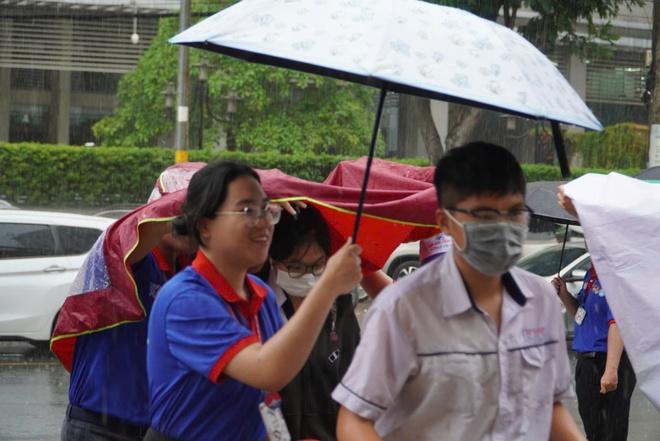 Bất chấp mưa đổ xối xả, tình nguyện viên che mưa tiếp sức thí sinh - Ảnh 12.