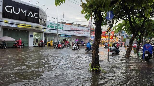 CSGT dùng xe đặc chủng chở người dân vượt đường ngập sâu giữa mưa lớn ở TP.HCM - Ảnh 1.